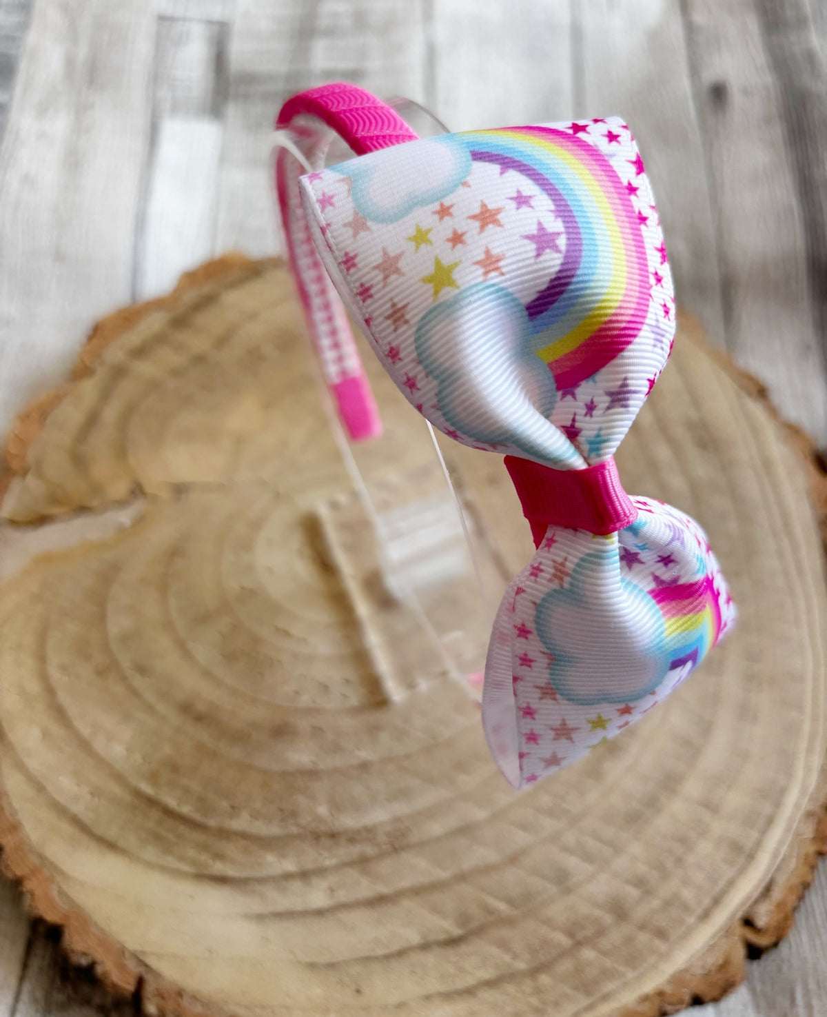 Close-up of rainbow and stars bow thin hairband handmade by Buttons and Bows