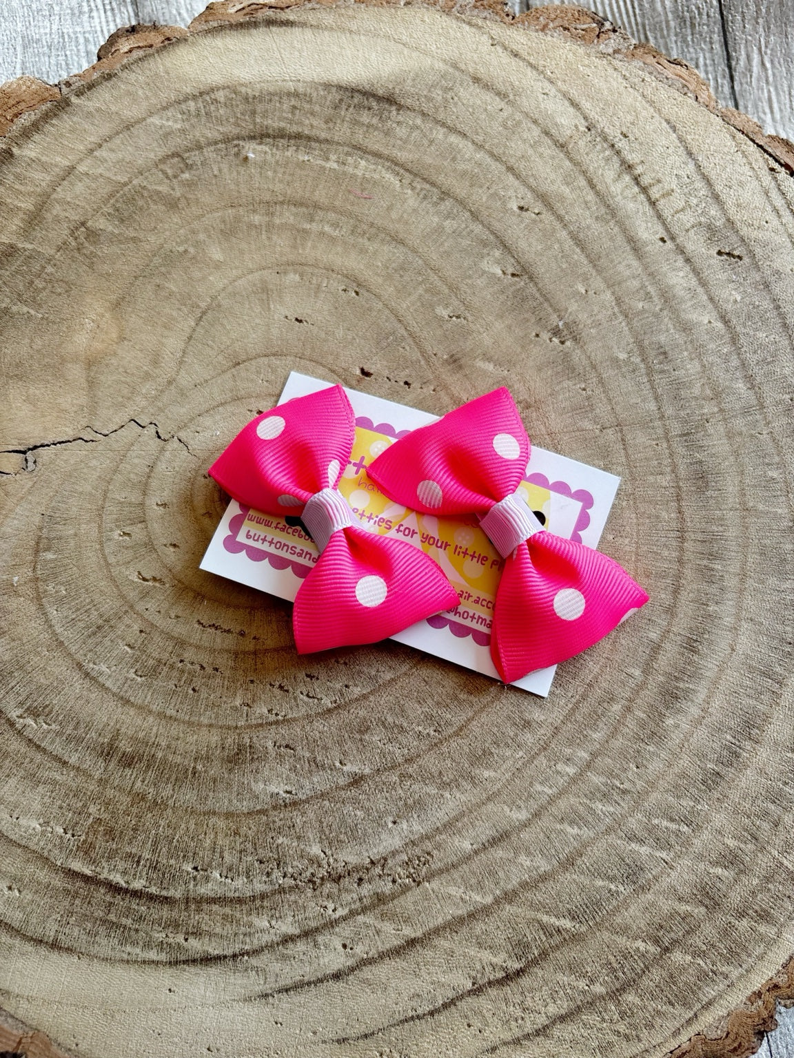 Bright pink polka dot handmade bow set on Buttons and Bows display card