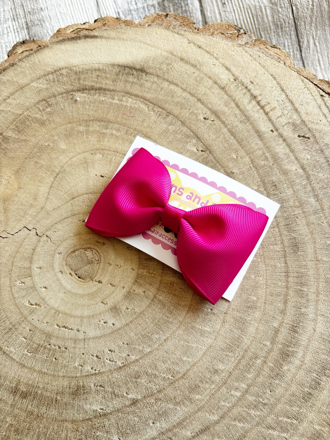 Hot pink handmade hair bow on Buttons and Bows display card