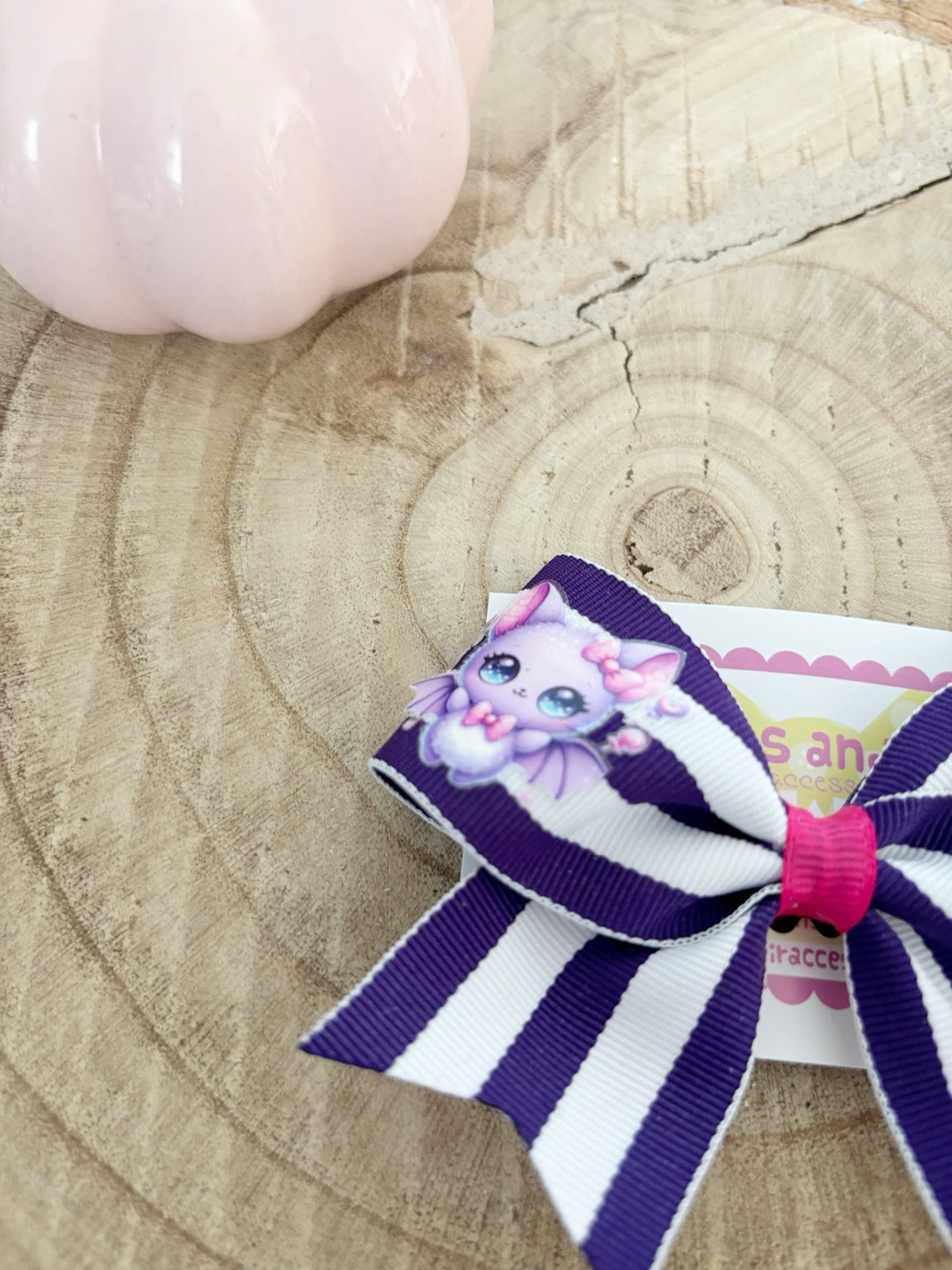 Close-up of purple and white striped Halloween single bow with cute bat embellishment