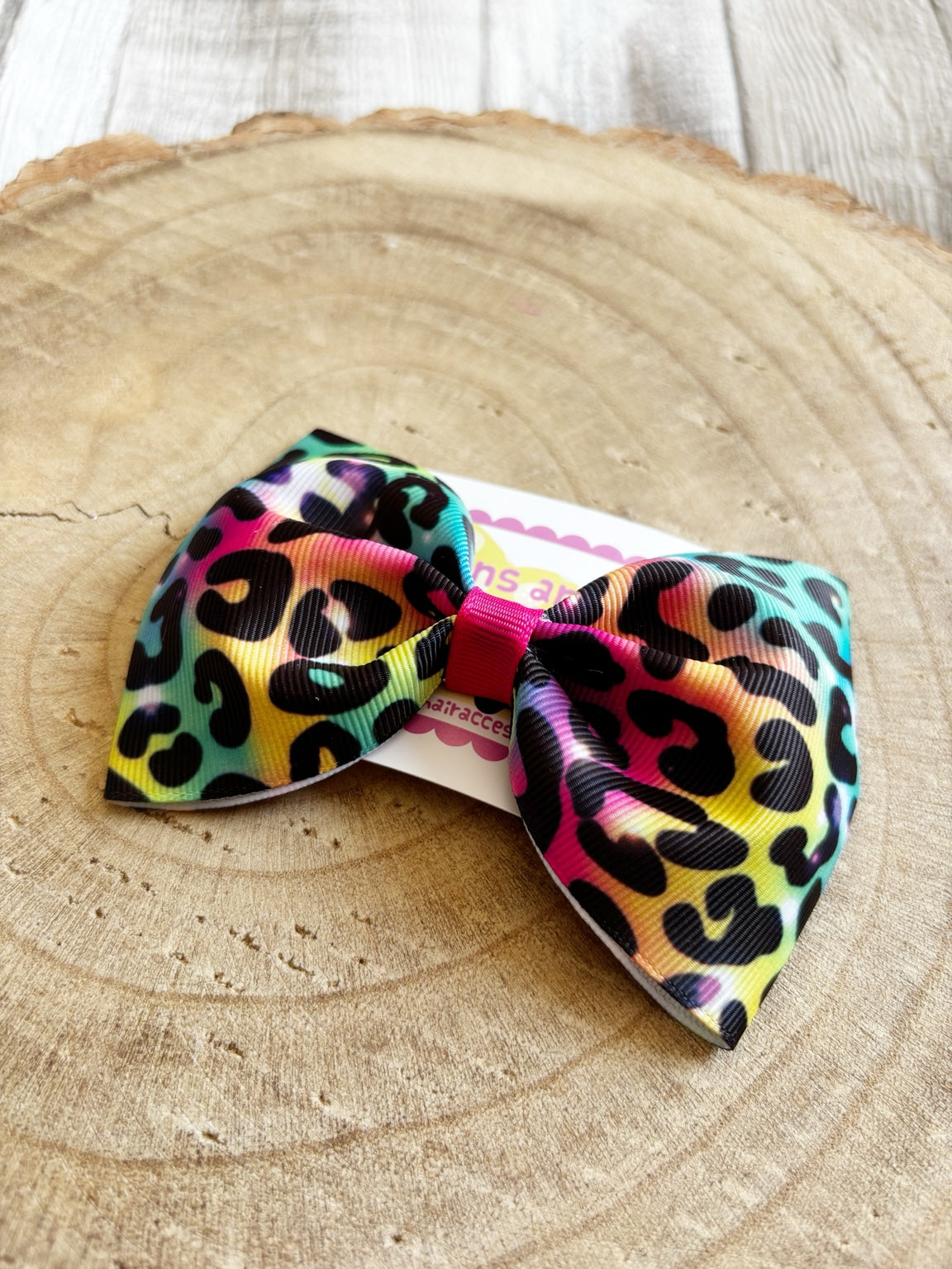 Close-up of rainbow leopard print single hair bow by Buttons and Bows