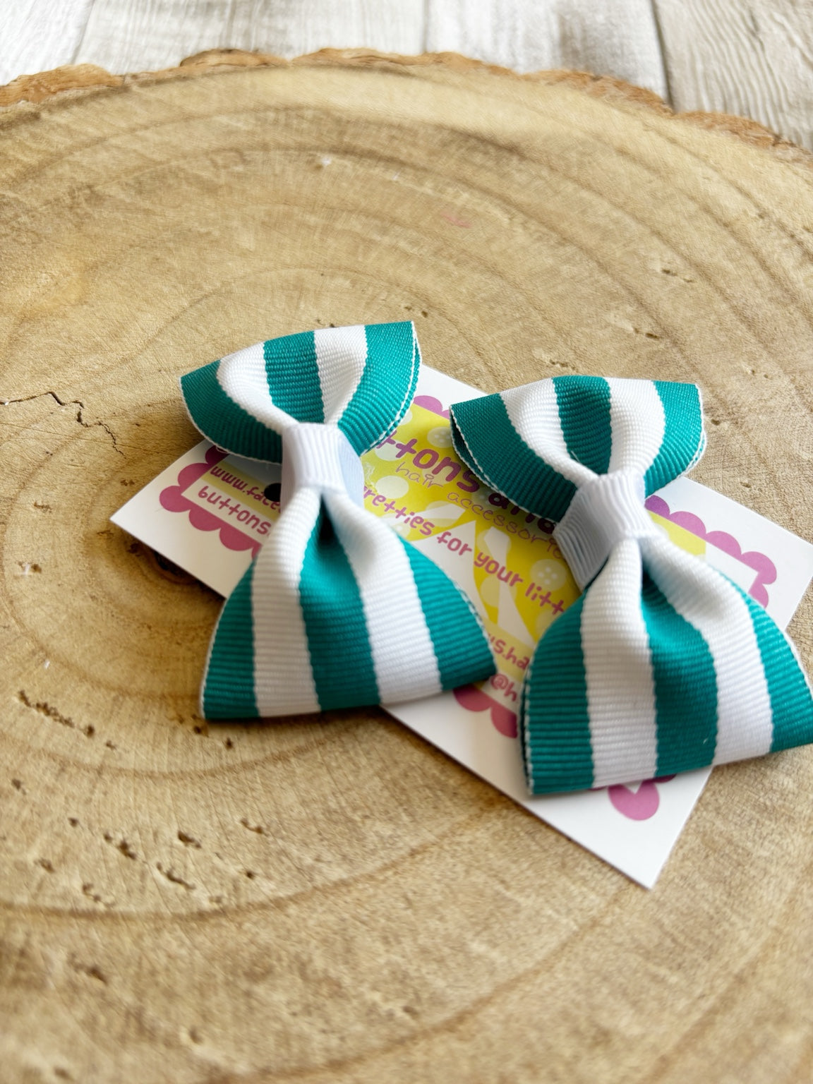 Close-up teal and white striped bow hair clips by Buttons and Bows
